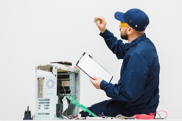 Uomo lateralmente che ripara un computer