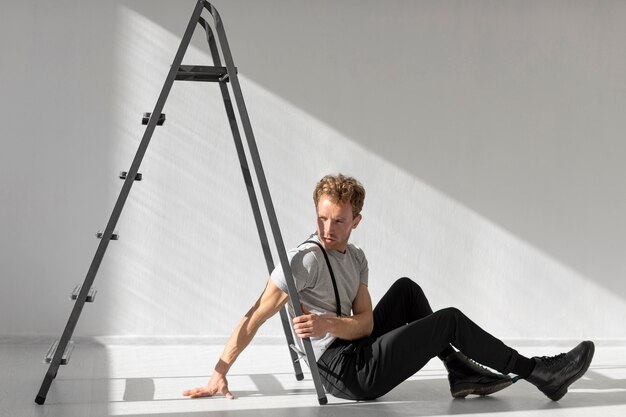 Sideways man sitting on the floor and ladder