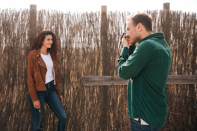 Sideways man taking photos of woman