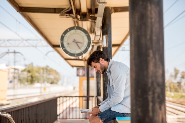 Foto gratuita uomo lateralmente che aspetta il treno