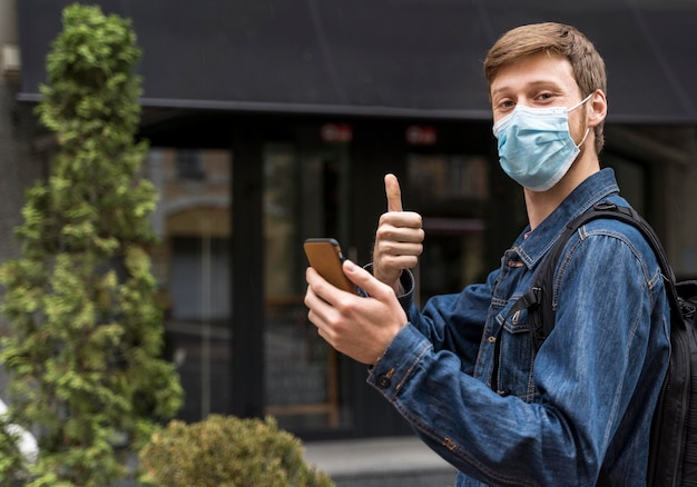 Sideways man walking outside with a medical mask on with copy space