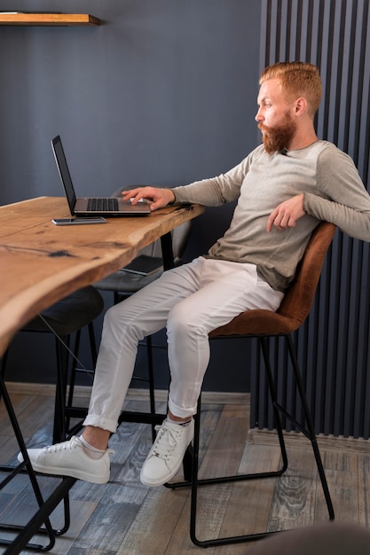 Sideways modern man working on laptop