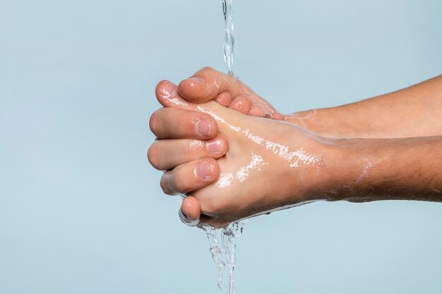 Боковой человек мыть руки, изолированные на синем