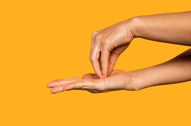 Sideways person washing hands isolated on orange