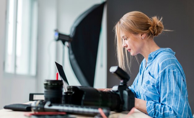 Боком фотограф женщина работает на скамейке