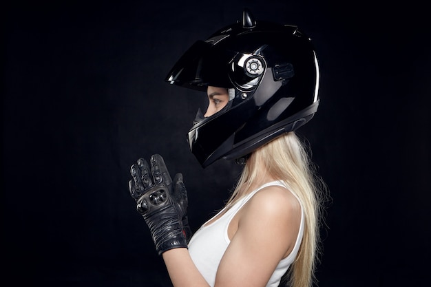 Боковой портрет модной молодой женщины-мотоциклиста с мускулистыми плечами
