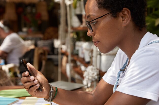 Sideways shot of black teenager wears transparent glasses