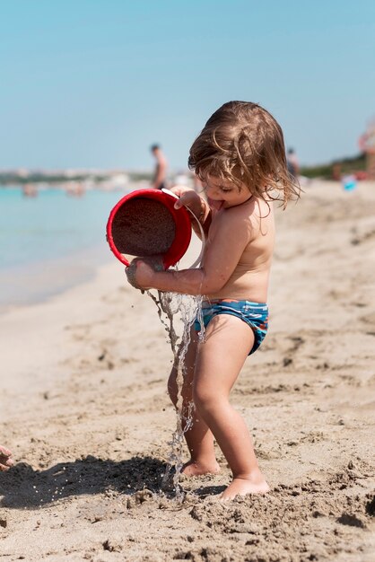 Sideways shot of a kid playing with sand bucket