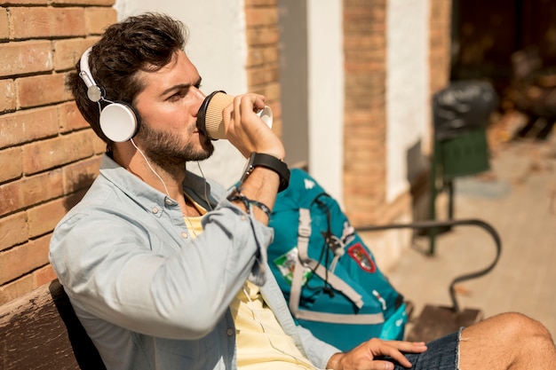 Viaggiatore lateralmente che beve caffè