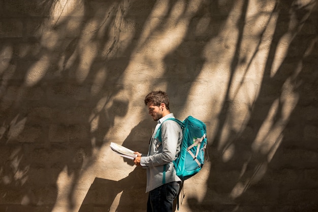 Free photo sideways traveler looking on map