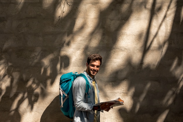 Бесплатное фото Боком путешественник, улыбаясь в камеру