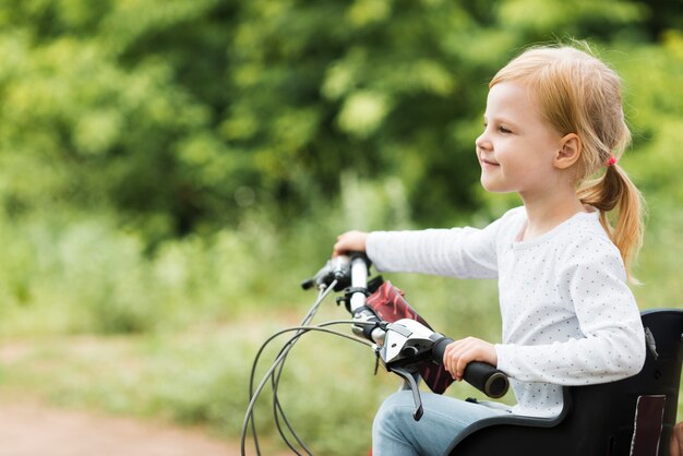 Sideways view little girl on bicycle