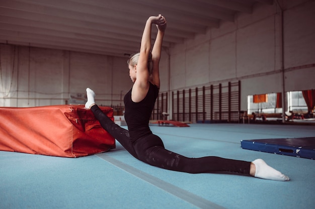 Sideways woman exercising for gymnastics olympics