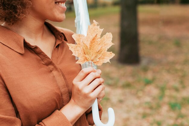 Free photo sideways woman holding a leaf with copy space