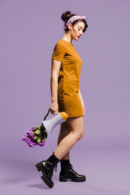 Sideways woman holding the megaphone and flowers