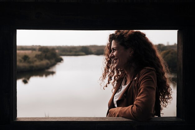 Sideways woman leaning against a window ledge