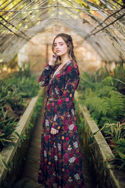 Sideways woman posing in a green house