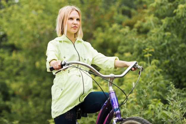 Free photo sideways woman riding her bike