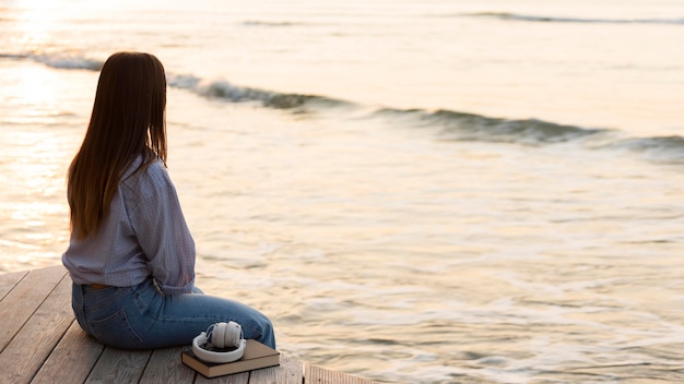 Sideways woman sitting and looking at the sea