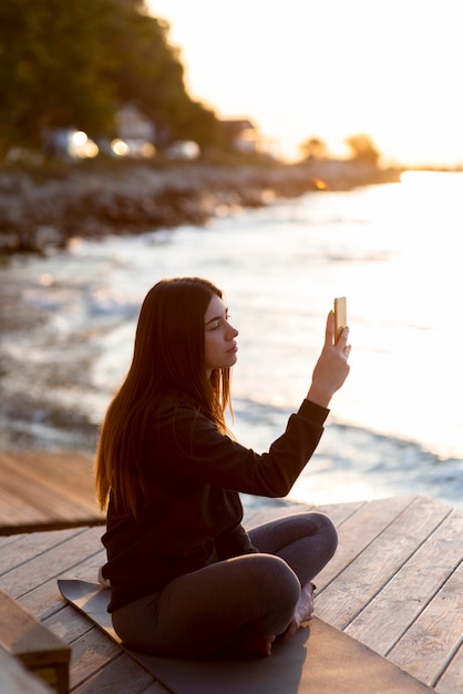 海の写真を撮る横向きの女性