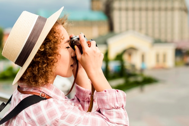 Sideways woman taking a photo with a camera