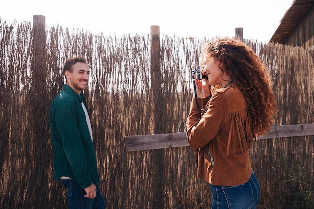 Sideways woman taking photos of man