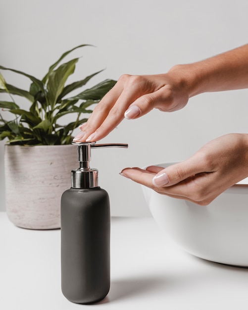 Free photo sideways woman using liquid soap