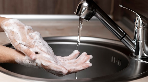 Боком женщина, мытье рук в раковине