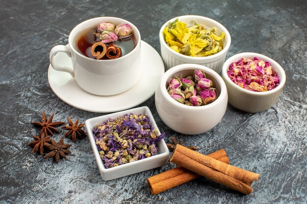 Sidewise shot of herbal tea with dry flowers on grey