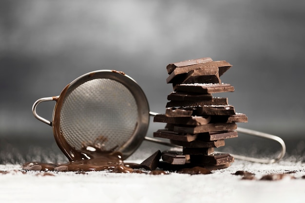 Sieve with melted chocolate and sugar