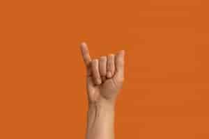 Foto gratuita simbolo della lingua dei segni isolato su orange