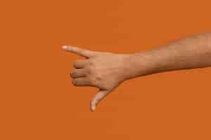 Free photo sign language symbol isolated on orange