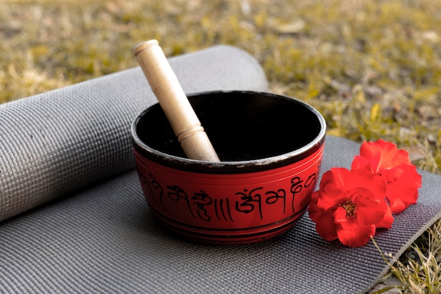 Signing bowl with yoga mat and flowers on the grass