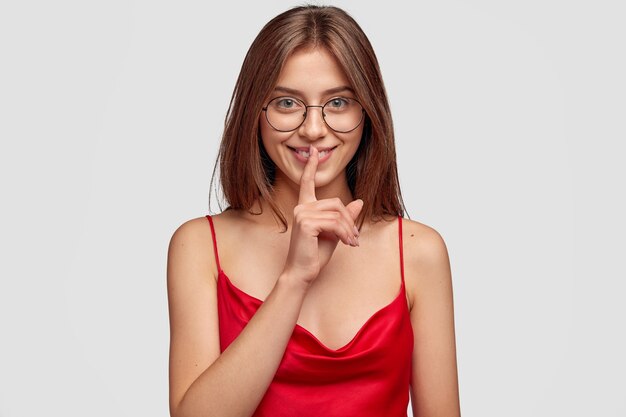 silent brunette young woman posing against the white wall