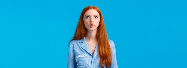 Free photo silent like fish cute and funny young redhead female with long ginger hair sucking lips as mimicking