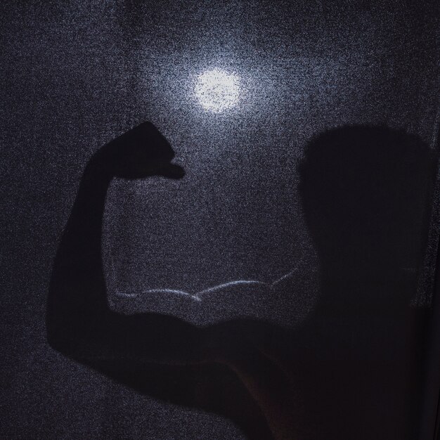 Silhouette of anonymous man flexing muscles