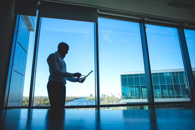 Silhouette of a business man in front of a window