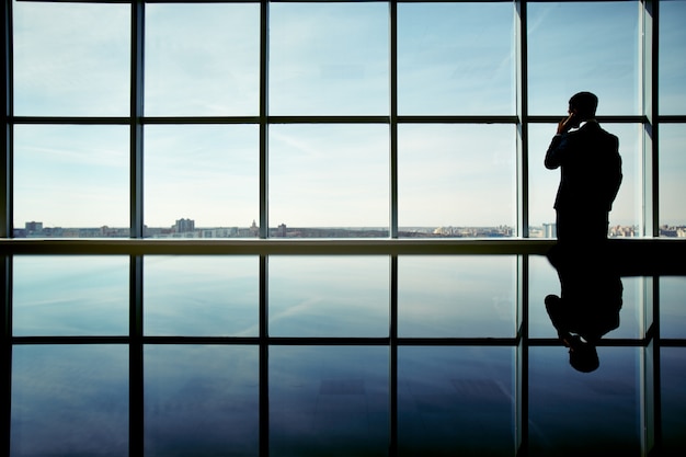 Foto gratuita silhouette di uomo d'affari godendo della vista