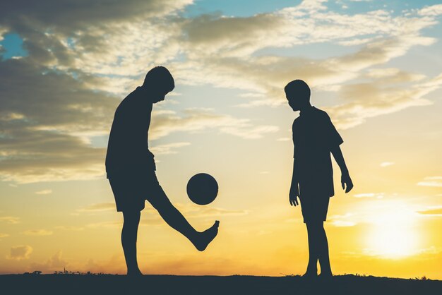 Silhouette of children play soccer football