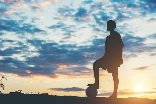 Silhouette di bambini giocano a calcio di calcio