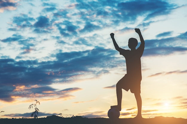 Silhouette of children play soccer football