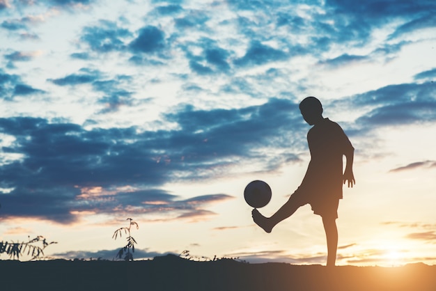 Foto gratuita silhouette di bambini giocano a calcio di calcio