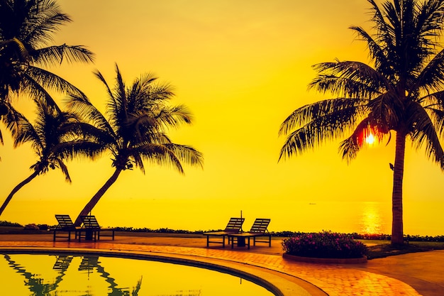 Free photo silhouette coconut palm tree with swimming pool