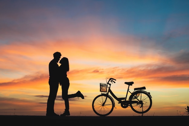 Silhouette of couple in love kissing in sunset. Couple in love concept.