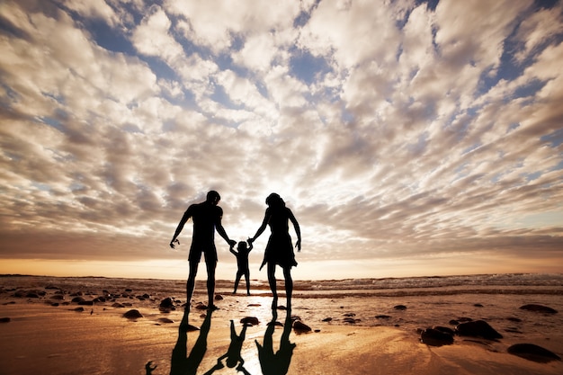 Silhouette of family playing on the beach