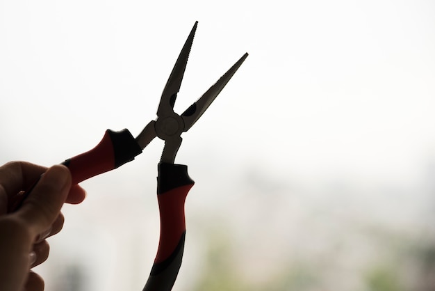 Silhouette of hand holding electric plier