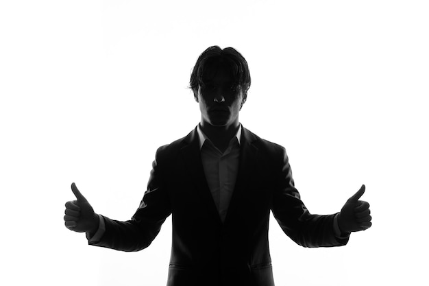 Silhouette of male in strict suit thumbs up back lit shadow white background