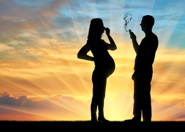 Silhouette of a man egoist smoking near a pregnant woman. she covered her nose with her hand from the smoke. the concept of a selfish person who thinks only of himself
