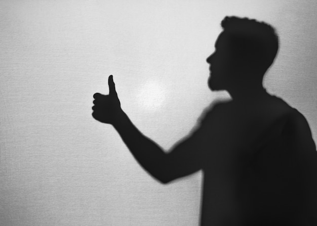 Silhouette of man gesturing thumb up