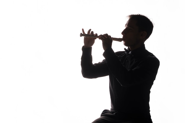 Free photo silhouette of a man playing the flute